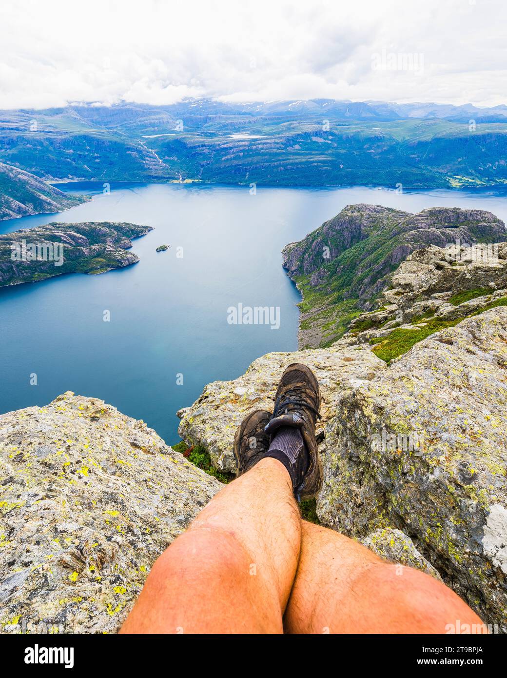 Niedriger Teil einer Wanderer, die auf dem Fjord sitzt Stockfoto
