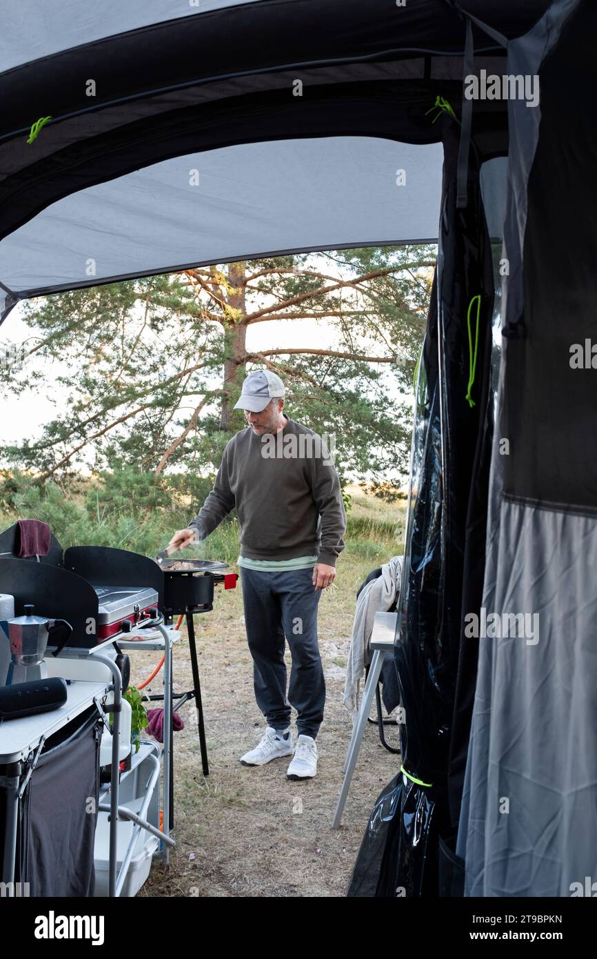 Ein Mann, der auf dem Campingplatz grillt Stockfoto