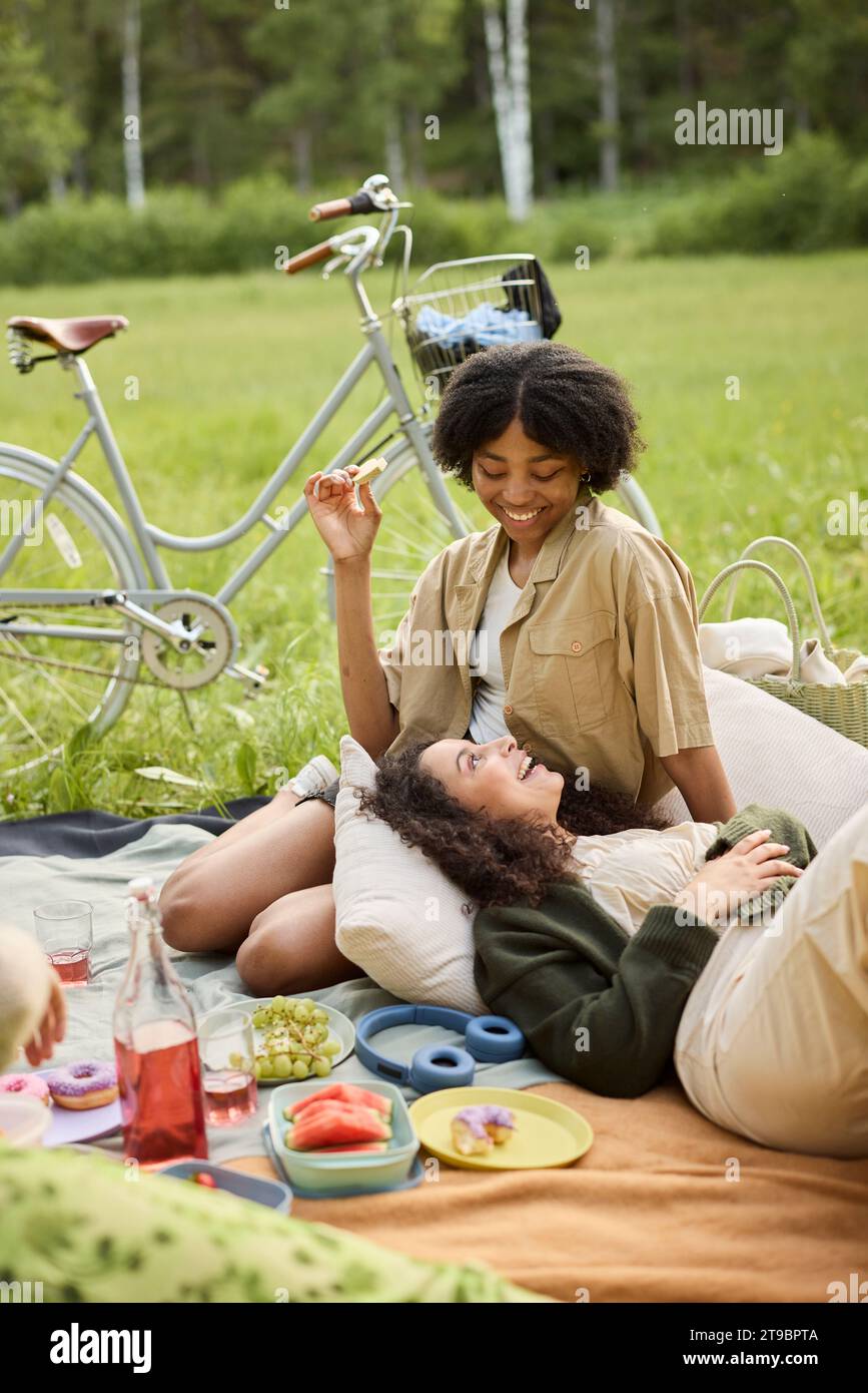 Glückliche Teenager-Mädchen, die sich beim Picknick entspannen Stockfoto