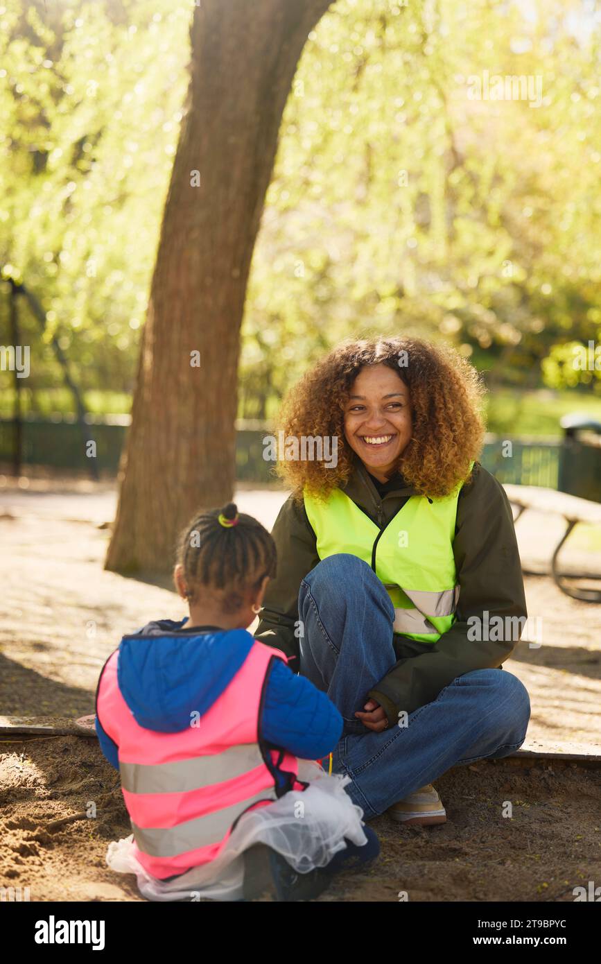 Freiwillige, die mit Mädchen im Park spielt Stockfoto