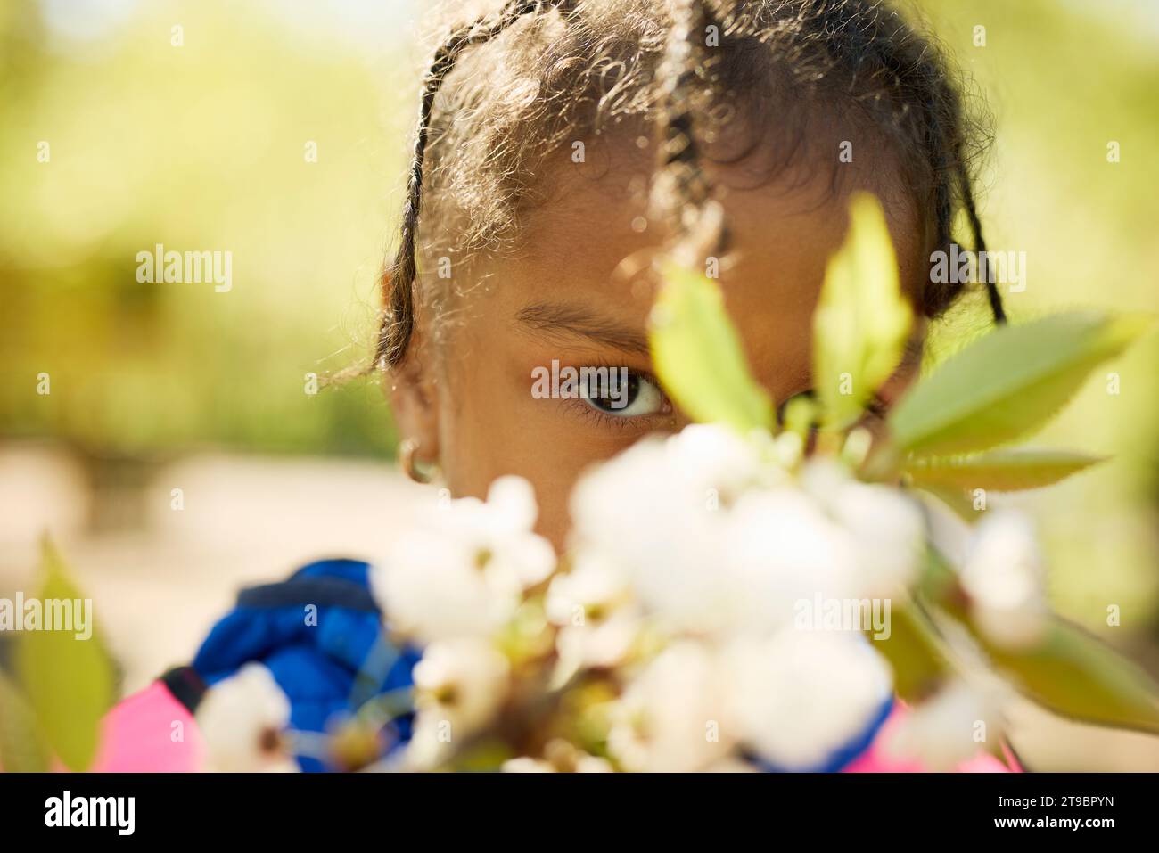 Porträt eines Mädchens, das sich hinter Blumen versteckt Stockfoto