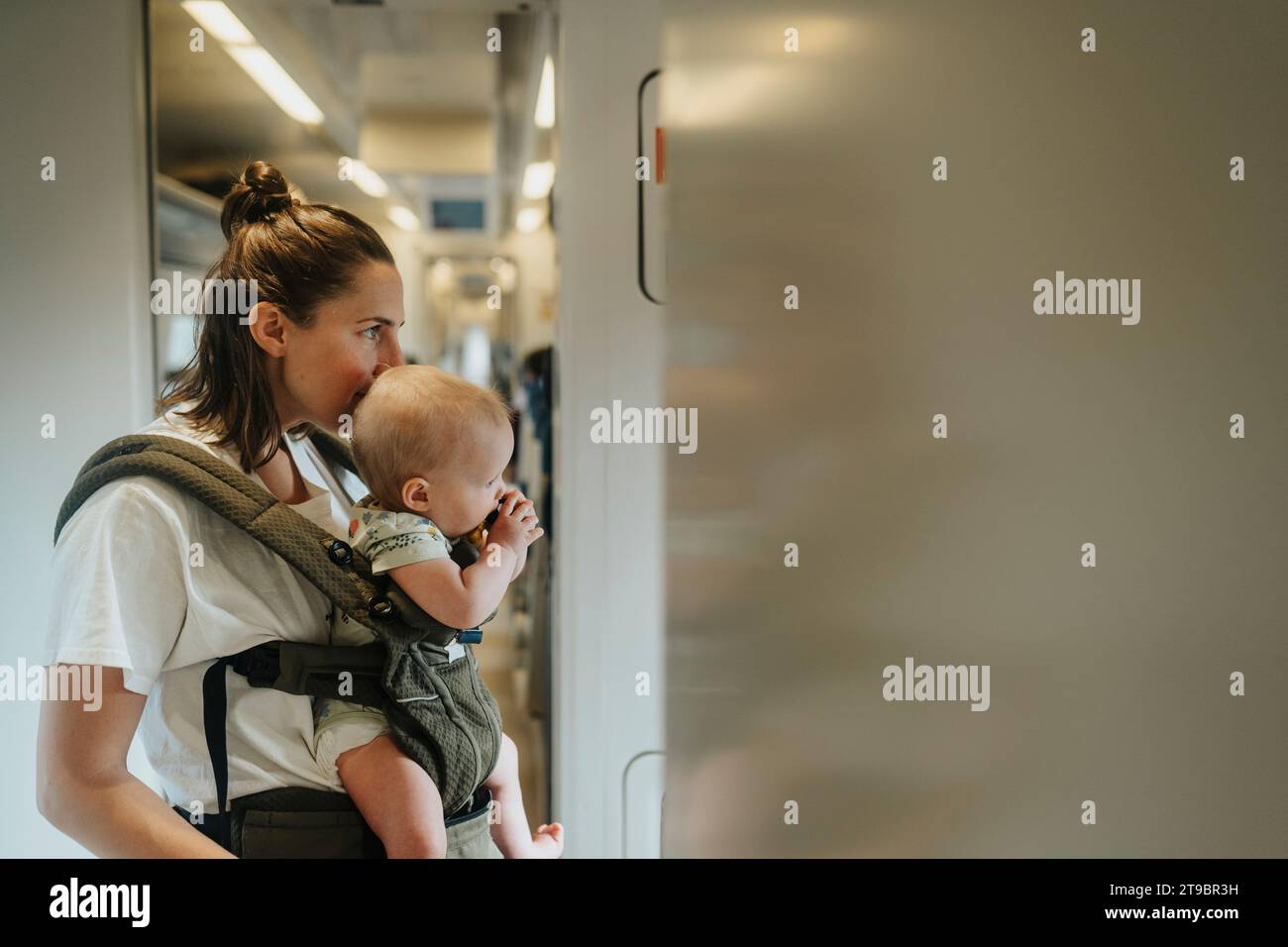 Mutter mit Baby im Zugkorridor Stockfoto