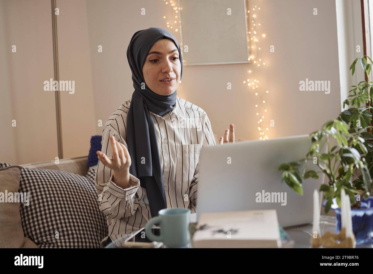 Eine junge Geschäftsfrau trägt Hijab und diskutiert über Videoanrufe über Laptop zu Hause Stockfoto