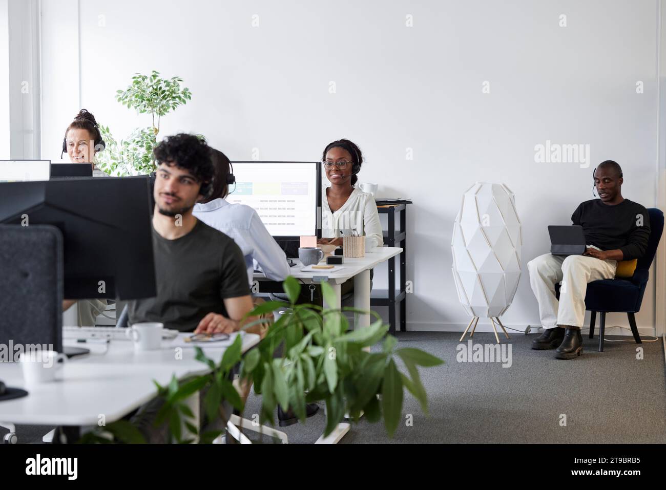 Leute, die im Büro sitzen und Computer benutzen Stockfoto