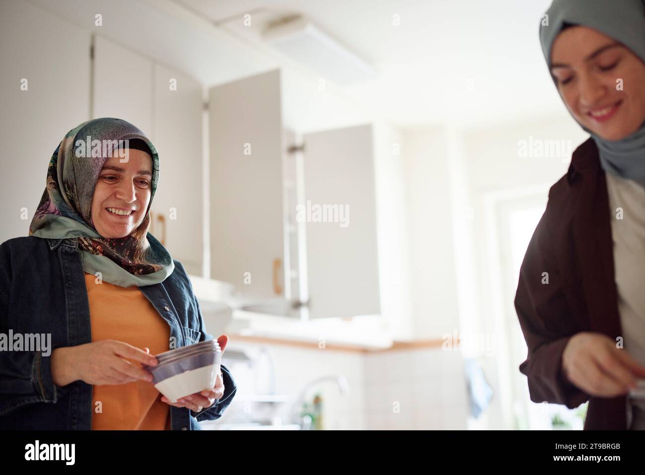 Frauen in Kopftüchern kochen gemeinsam für eid al-fitr zu Hause Stockfoto