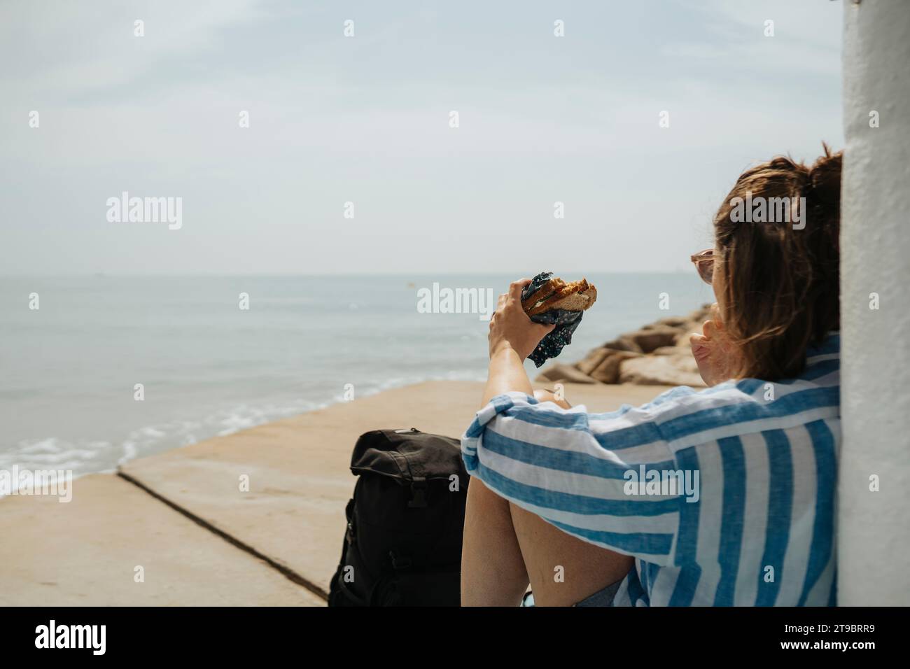 Junge Frau, die sich am sonnigen Tag am Strand entspannt Stockfoto