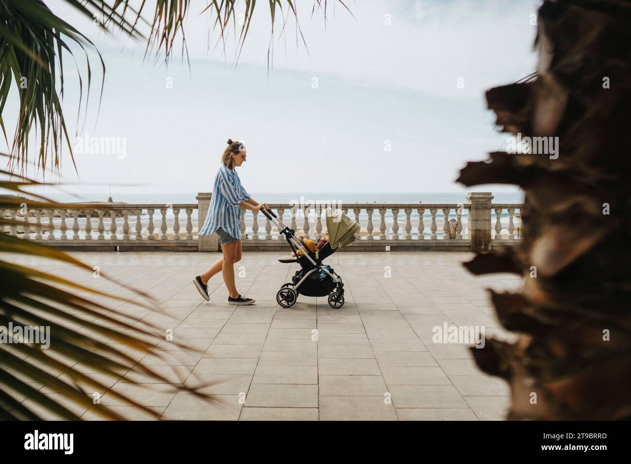 Mutter mit Baby, die in der Nähe des Strandes läuft Stockfoto