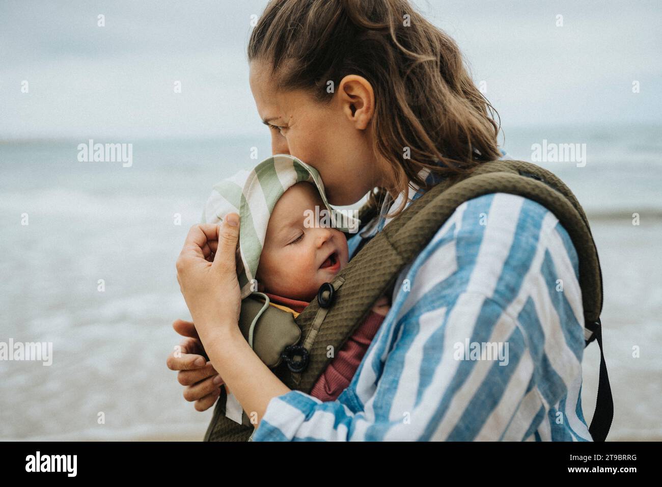 Mutter mit Baby, die am Strand relaxt Stockfoto