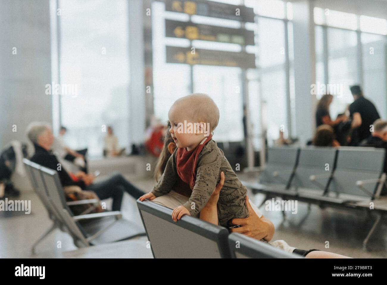 Mutter mit Baby wartet am Flughafen Stockfoto