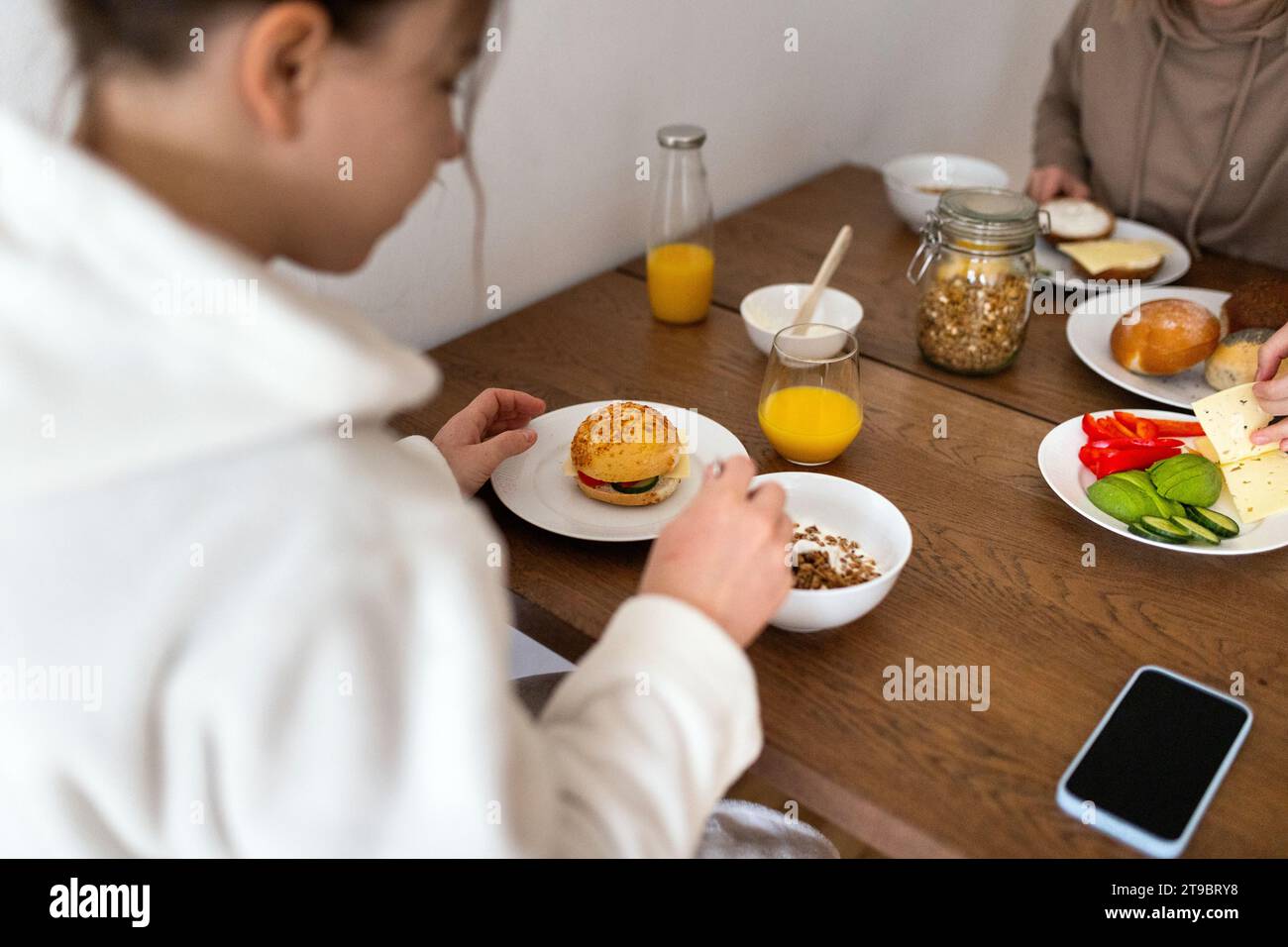 Junge lesbische Frauen essen zusammen am Esstisch frühstücken Stockfoto