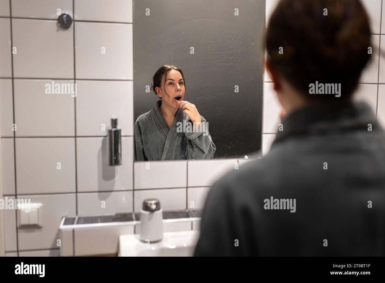Spiegelreflexion junger Zahnputzfrauen im Badezimmer Stockfoto