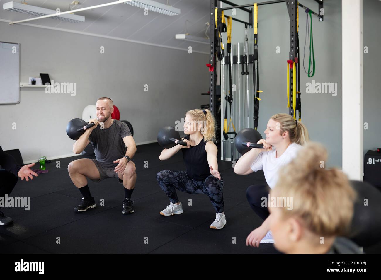 Männer und Frauen, die mit Kettlebells im Health Club trainieren Stockfoto