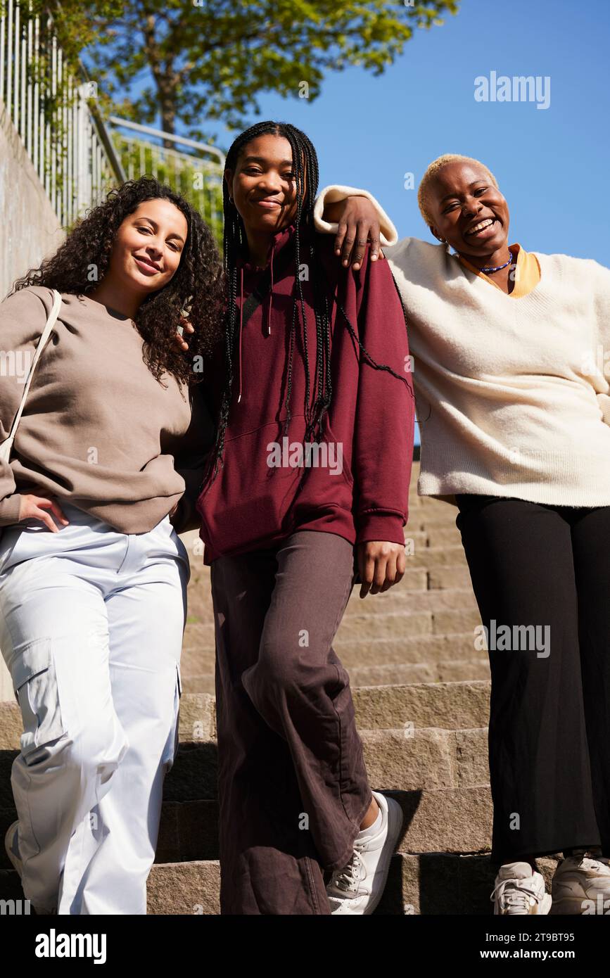 Tiefwinkelporträt glücklicher junger multirassischer Freunde auf der Treppe Stockfoto
