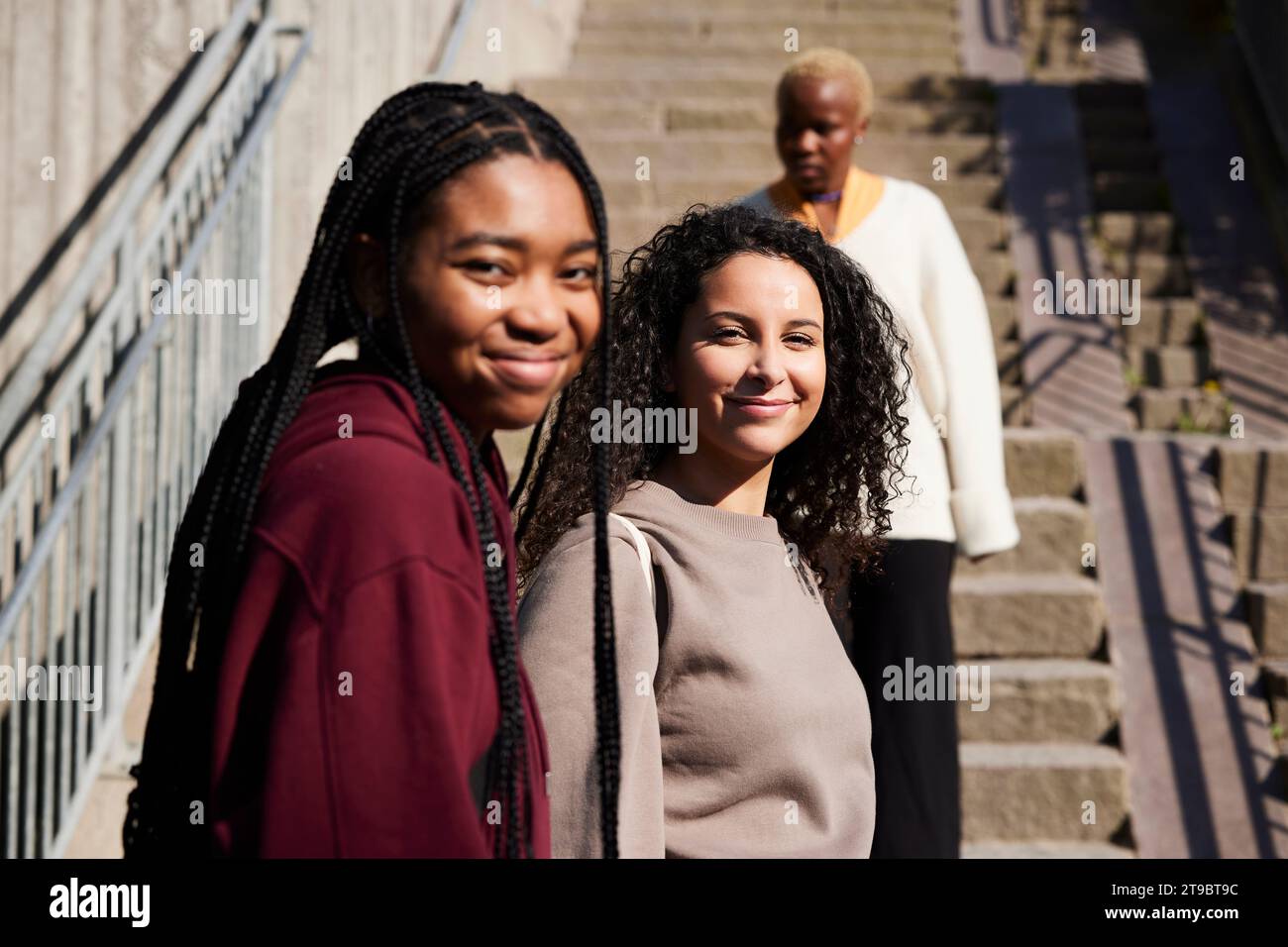 Porträt glücklicher junger multirassischer Freunde gegen Treppe Stockfoto