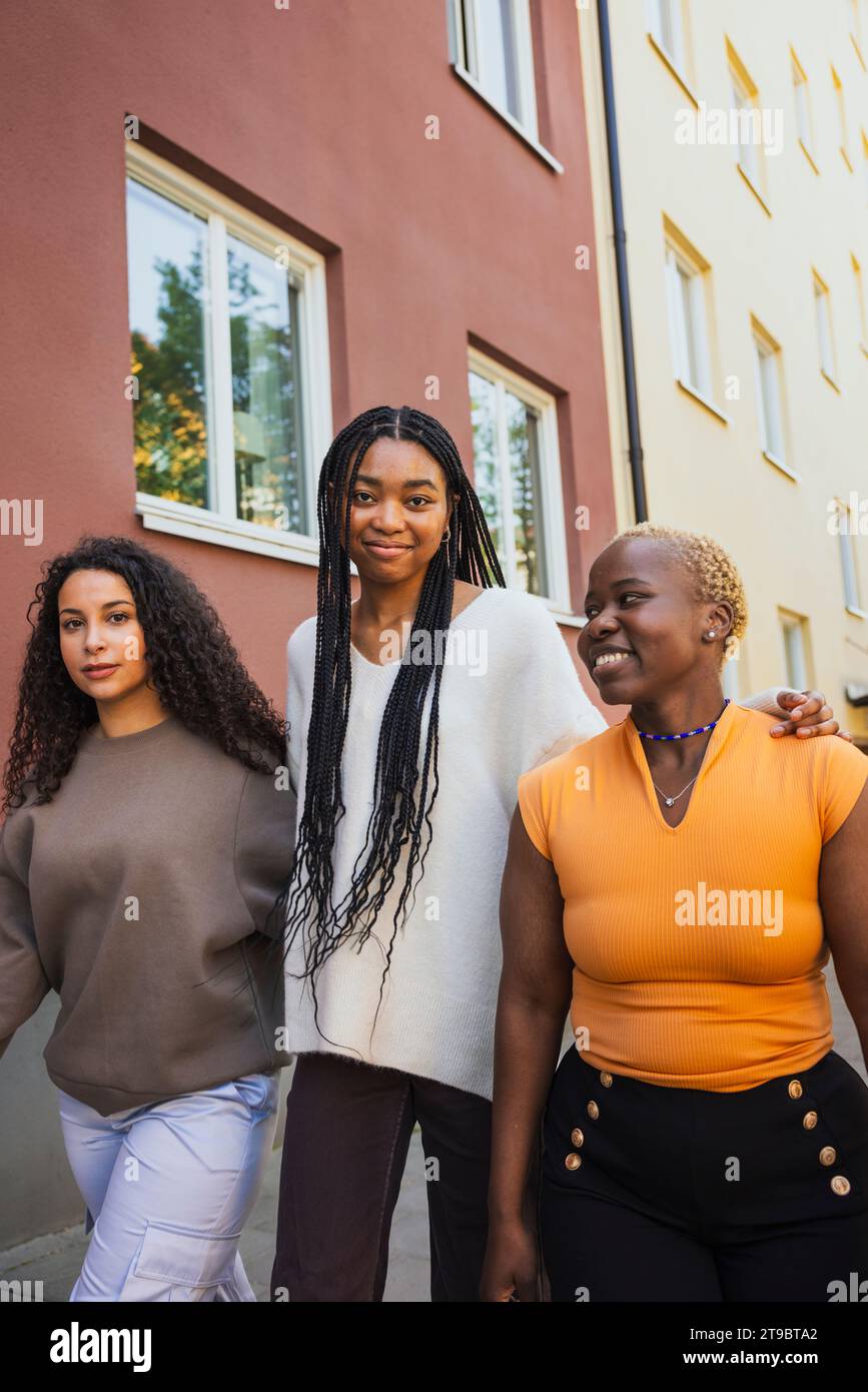 Multirassische junge Frauen, die am Wochenende beim Bauen vorbeigehen Stockfoto