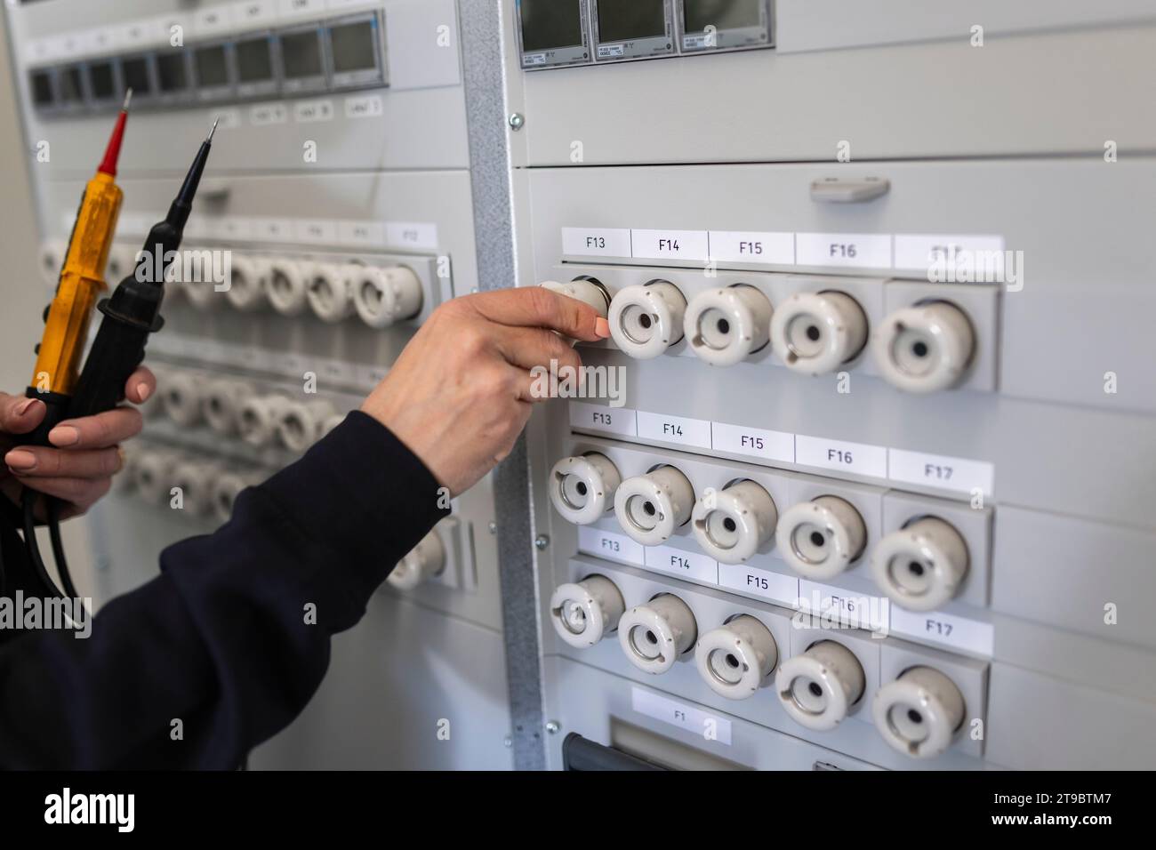 Hand einer Technikerin, die den elektrischen Sicherungskasten bedient Stockfoto