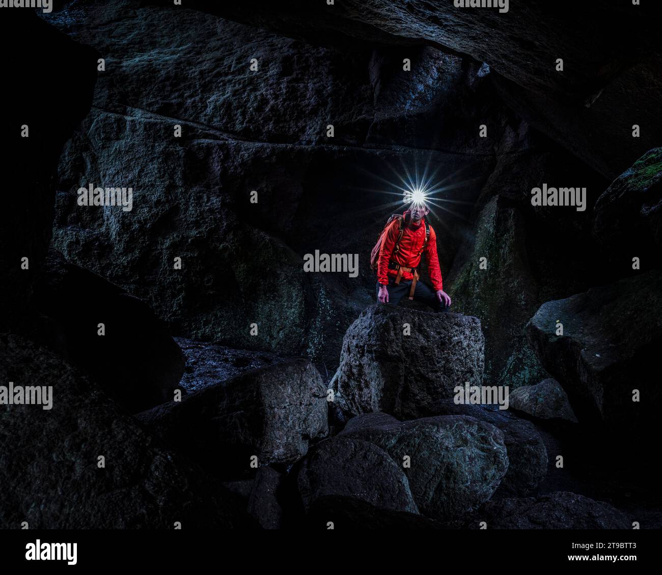 Mann mit Scheinwerfer, der die Höhle erforscht Stockfoto
