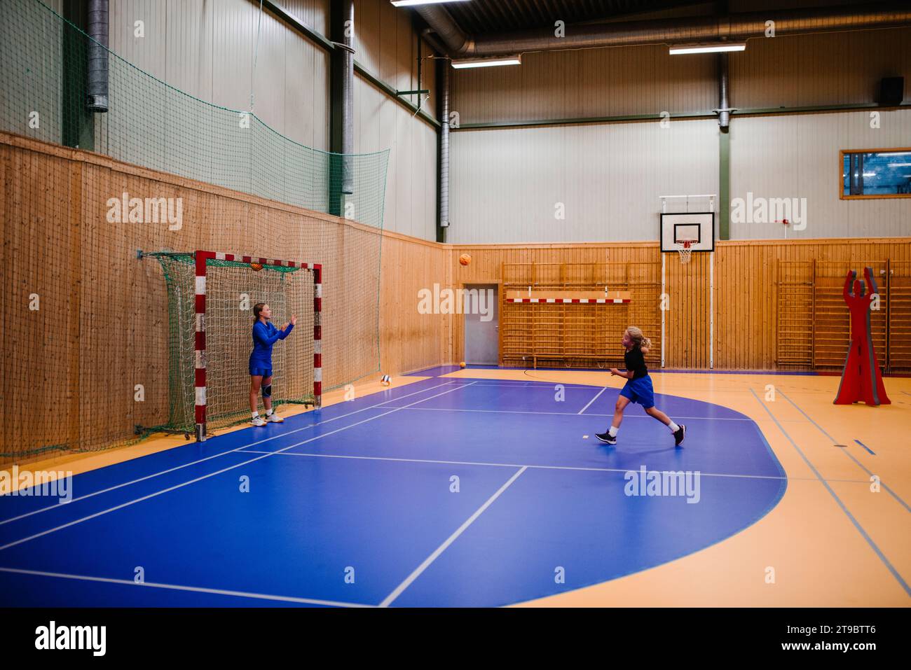 Mädchen üben Handball miteinander auf dem Sportplatz Stockfoto