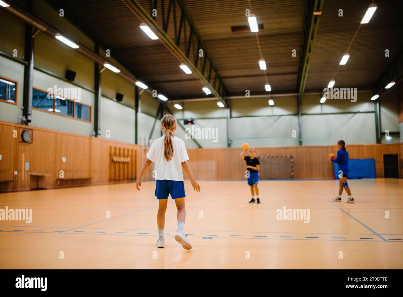 Freundinnen spielen Handball auf dem Sportplatz Stockfoto