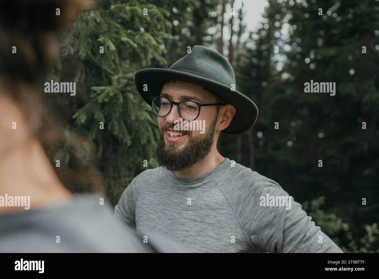 Lächelnder bärtiger Mann mit Brille und Hut Stockfoto