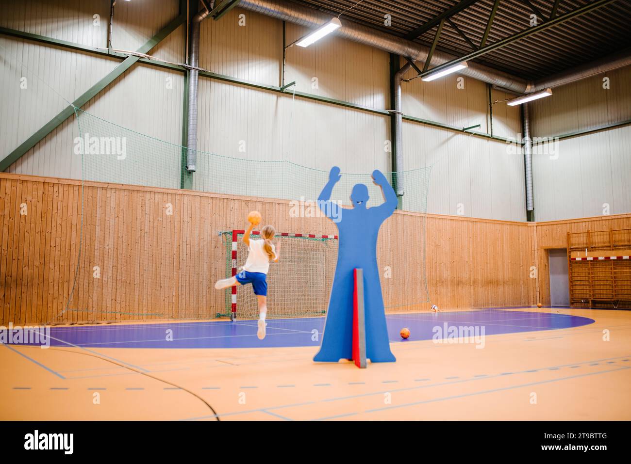 Handballspielerin mit Ball auf dem Sportplatz Stockfoto