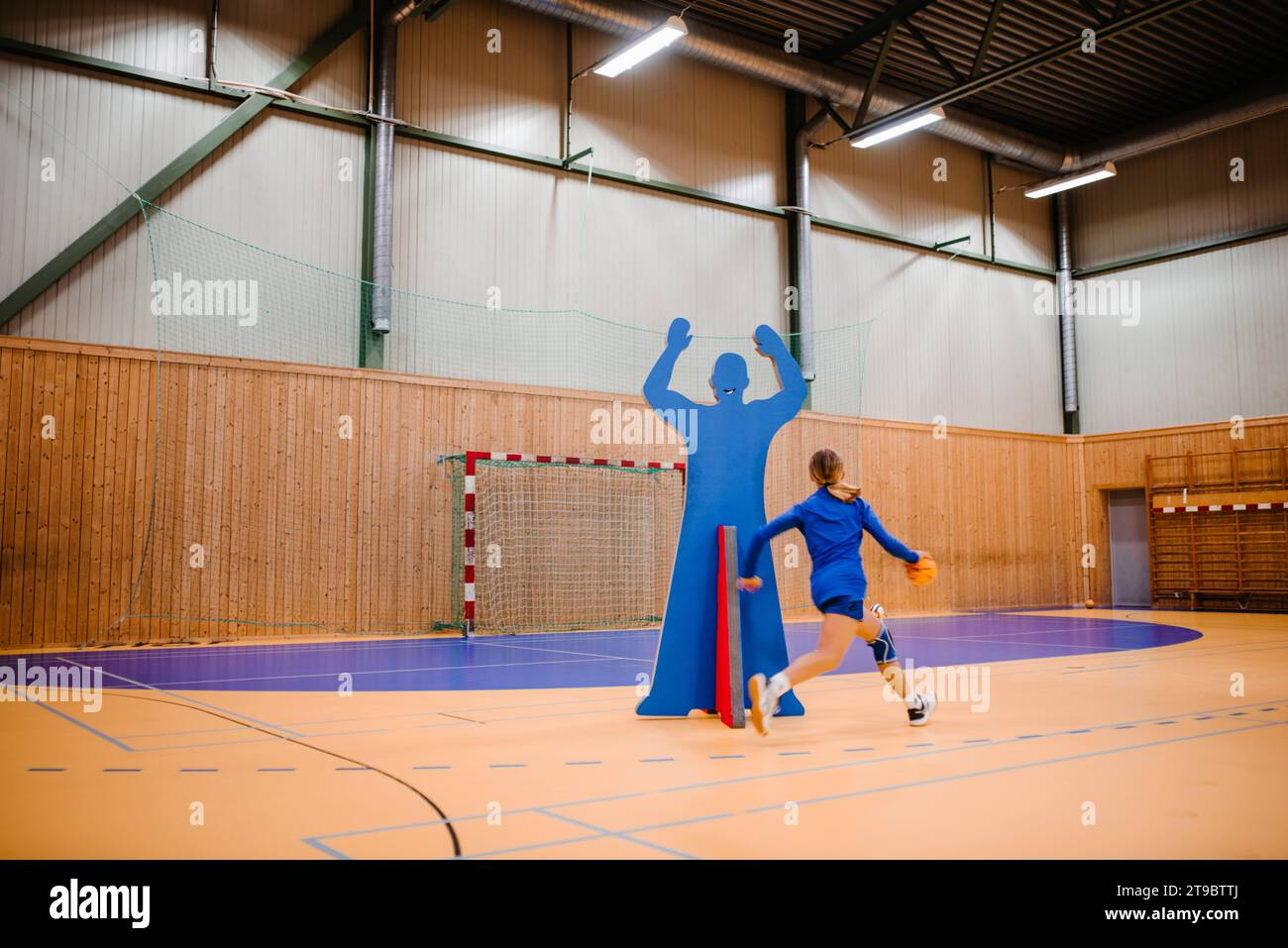 Handballspielerin, die mit Ball auf dem Sportplatz läuft Stockfoto