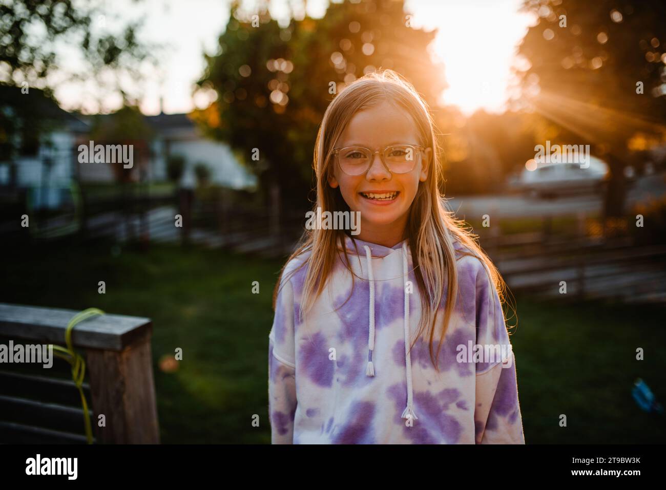 Porträt eines glücklichen Mädchens, das während des Sonnenuntergangs einen Hoodie trägt Stockfoto