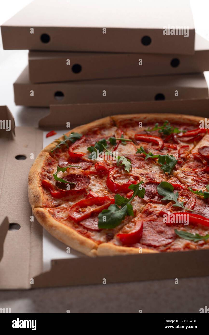 Große Pizza im offenen Karton auf dem Küchentisch aus der Nähe Stockfoto