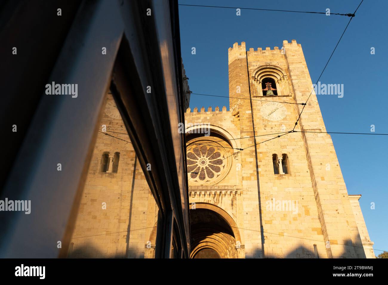 SE Kathedrale von Lissabon spiegelt sich am Fenster der historischen Straßenbahn 28 bei Sonnenuntergang. Portugal Stockfoto