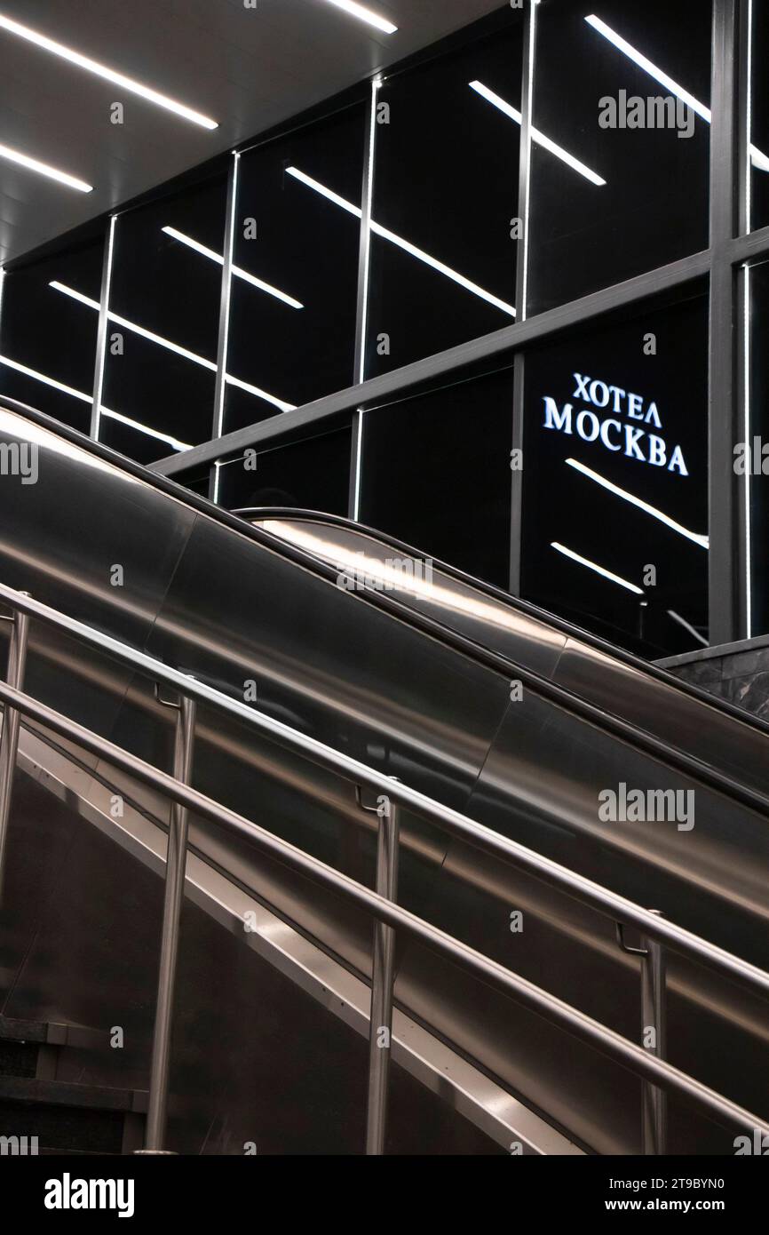Belgrad, Serbien - 20. November 2023: U-Bahn-Treppentreppe mit Lichterspiegelung und Hotel Moskau Schild in kyrillischer Schrift in der Nacht, Detail Stockfoto
