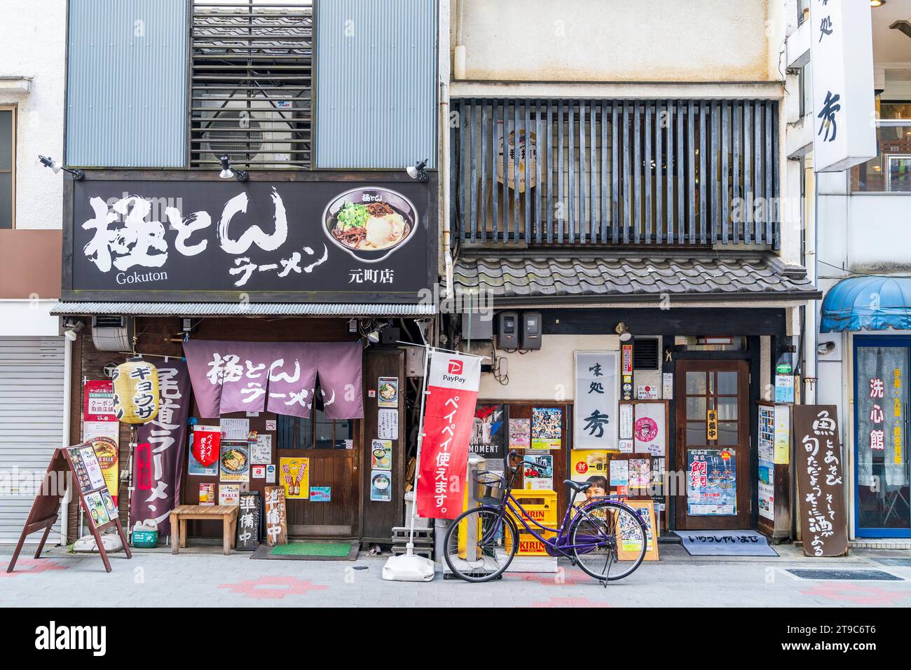 Restaurant Gokuton Ramen Kannabe in Fukuyama, Japan. Typisches Restaurant im alten Stil mit nordischen Vorhängen, vielen Schildern und Menüs, die über der Vorderseite verputzt sind. Stockfoto