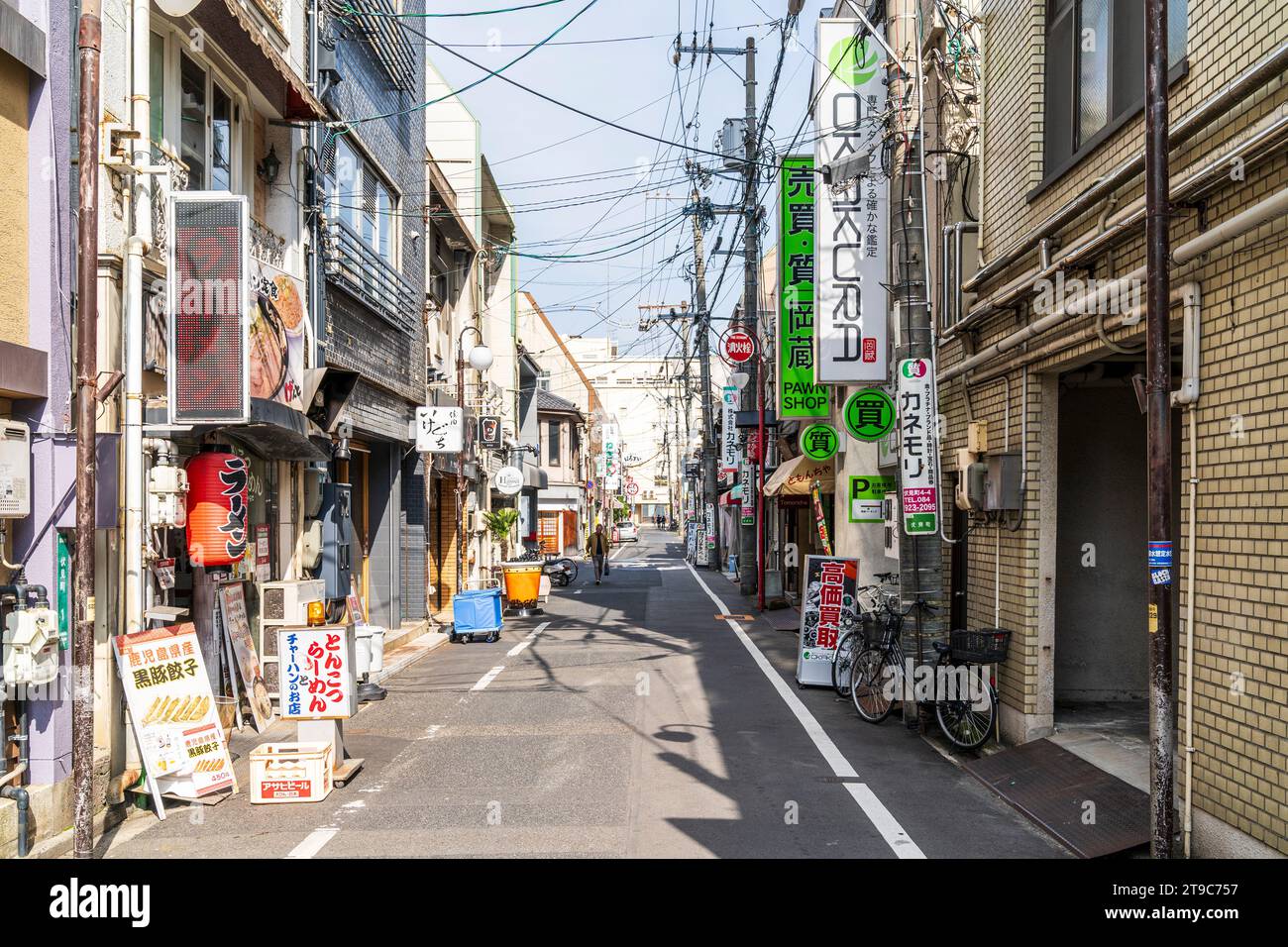 Typisch schmale japanische Stadtstraße ohne Bürgersteig und einspurige Stromleitungen über Betonmasten. Fukuyama. Stockfoto