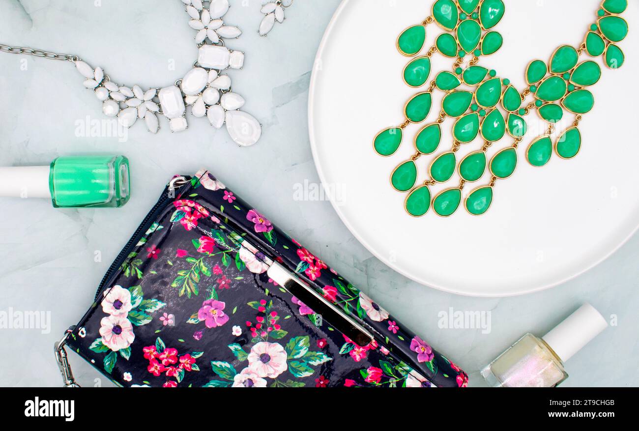 Grüner und weißer Schmuck und nagellack, flacher Schnitt mit floralem Clutch-Outfit Stockfoto