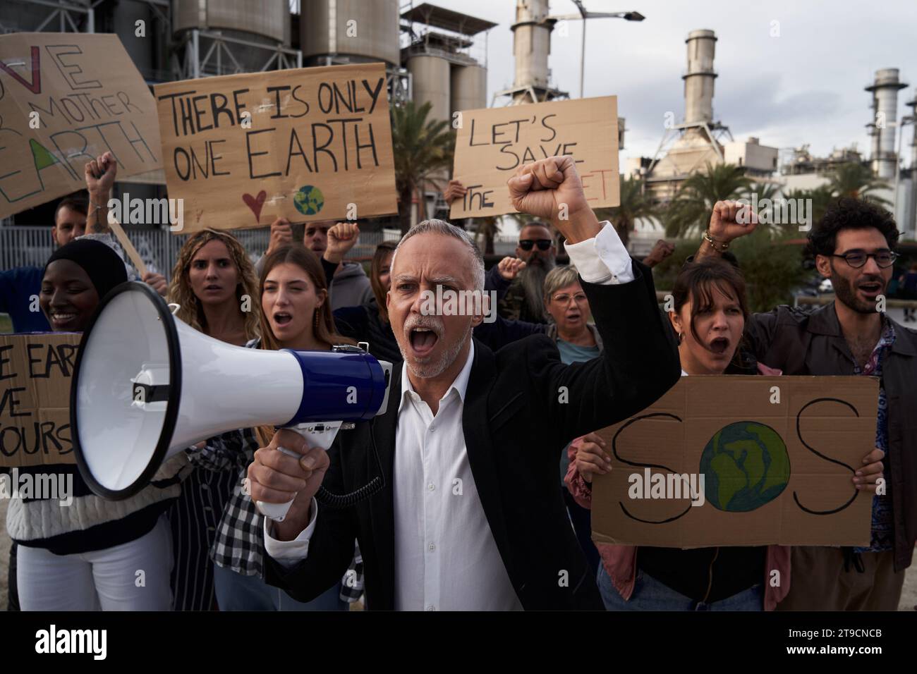 Reifer Mann, der mit Megaphon gegen Verschmutzung protestiert. Stockfoto