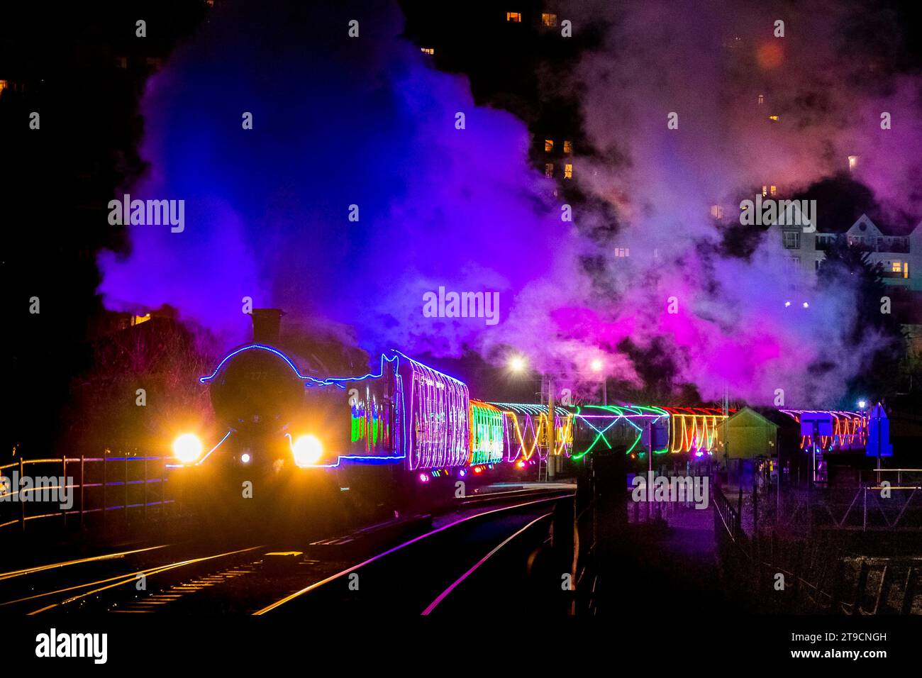 Kingswear, Devon, Großbritannien. November 2023. Der Christmas Train of Lights auf der Dartmouth Steam Railway, der zwischen dem 24. November und dem 30. Dezember 2023 verkehrt, fährt von der Kingswear Station in Devon auf dem Weg nach Paignton ab. Die Wagen und Dampflokomotiven des Festdienstes sind innen und außen mit farbigen Lichtern beleuchtet. Bildnachweis: Graham Hunt/Alamy Live News Stockfoto