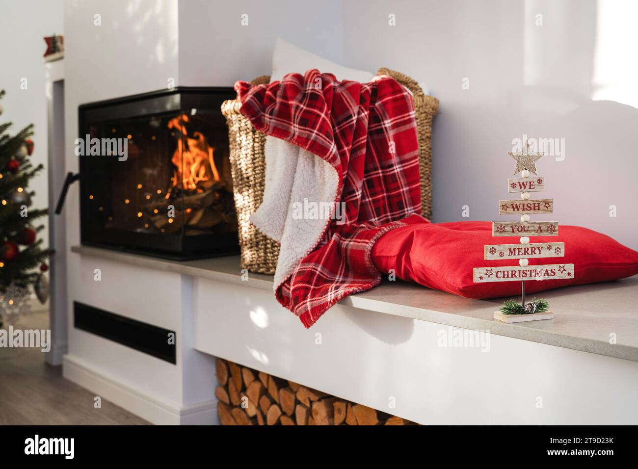 Innenraum eines modernen Wohnzimmers mit brennendem Kamin, geschmückt mit Weihnachtsdekoration. Stockfoto