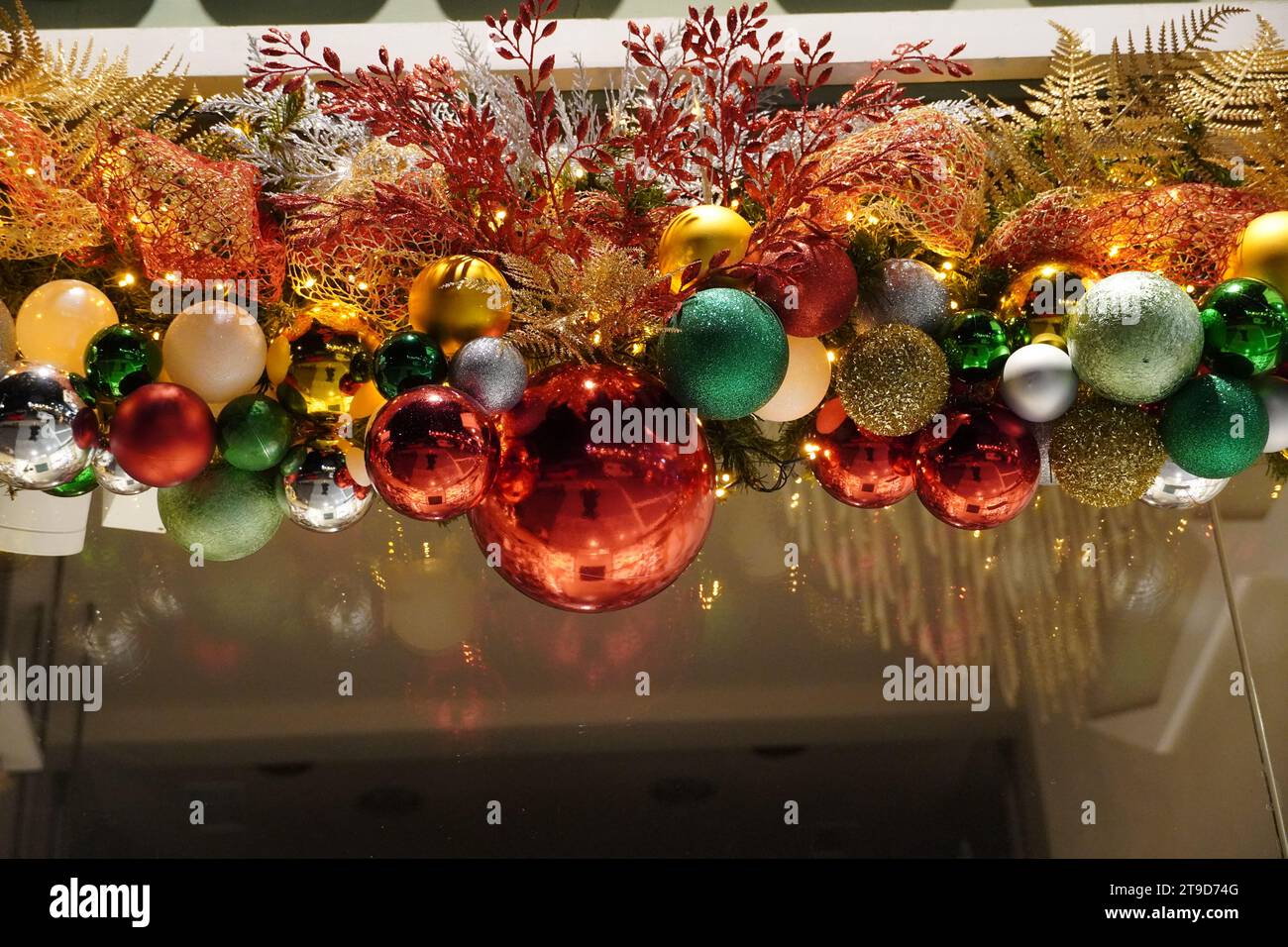 Weihnachtsdekoration mit bunten Kugeln, über einer Tür Stockfoto