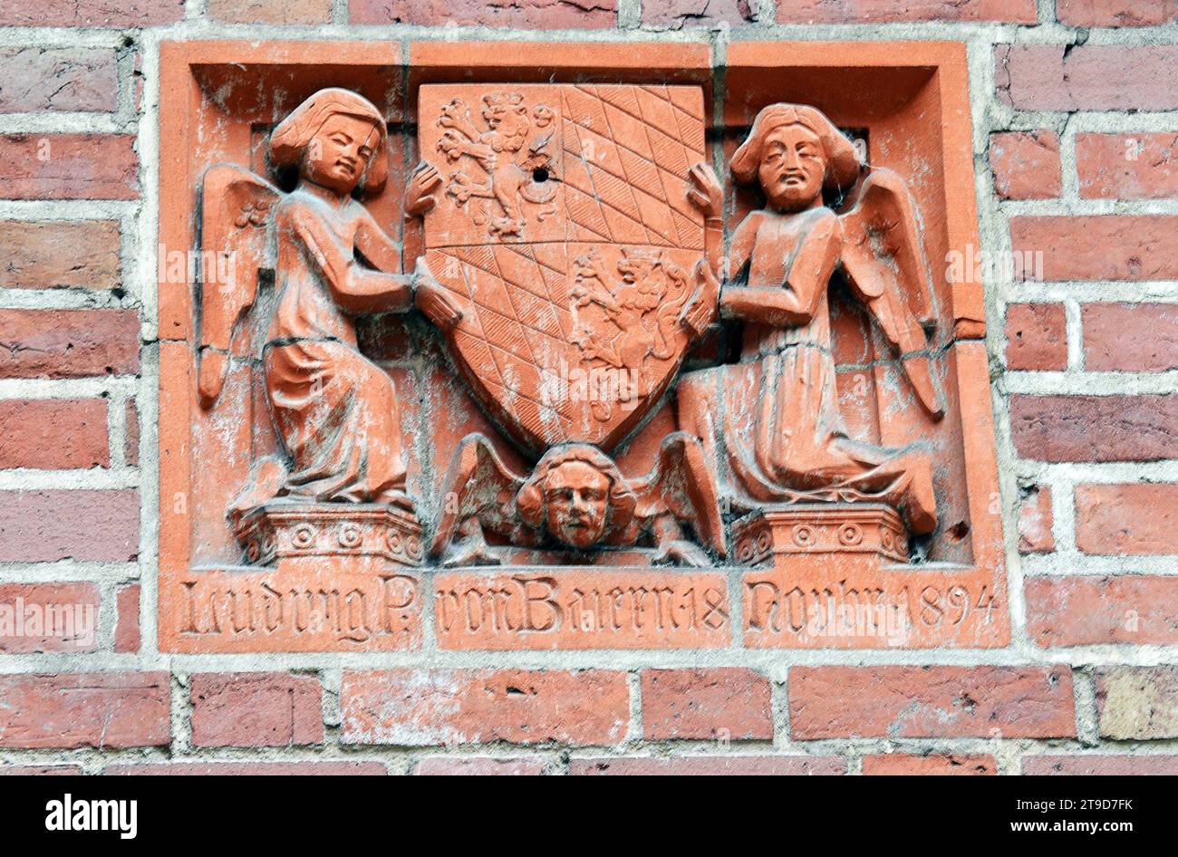 MALBORK, POLEN - 6. NOVEMBER 2023: Eine geschnitzte rote Sandsteintafel an der Burgmauer, datiert 1894 zu Ehren von Ludwig, Fürst von Bayern, Stockfoto