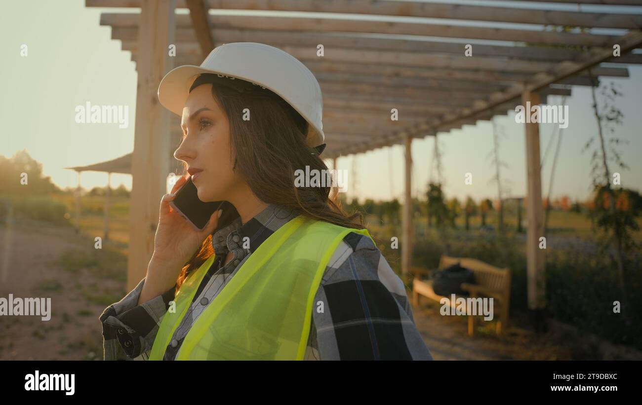 Kaukasische Frau Mädchen Öko-Ingenieur weibliche Architektin Geschäftsfrau Inspektorin Arbeitsuniform Schutzhelm sprechen Mobiltelefongeschäft Stockfoto