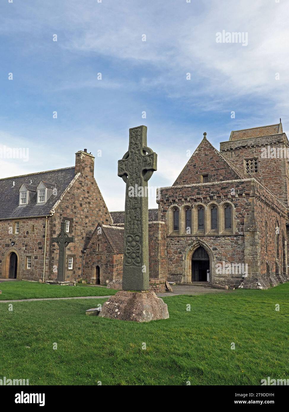 Historisches St. Martin's Cross aus dem 9. Jahrhundert vor der ikonischen, aus Stein erbauten Iona Abbey auf der hebridischen Insel Iona, Schottland, Großbritannien Stockfoto