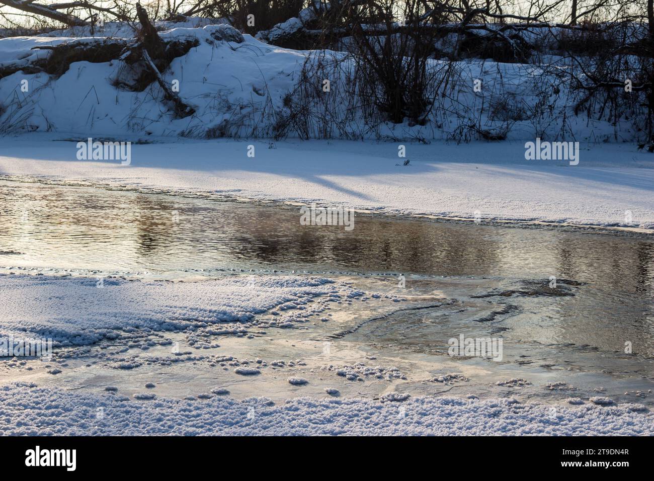 Im Winter auf einem nicht vollständig gefrorenen Fluss auftauen, gefährlicher Zugang zu Eis Stockfoto