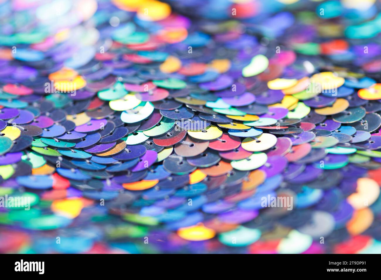 Nahaufnahme eines glänzenden, mehrfarbigen Paillettenmaterials aus miteinander verbundenen bunten Metallkreisen. Stockfoto