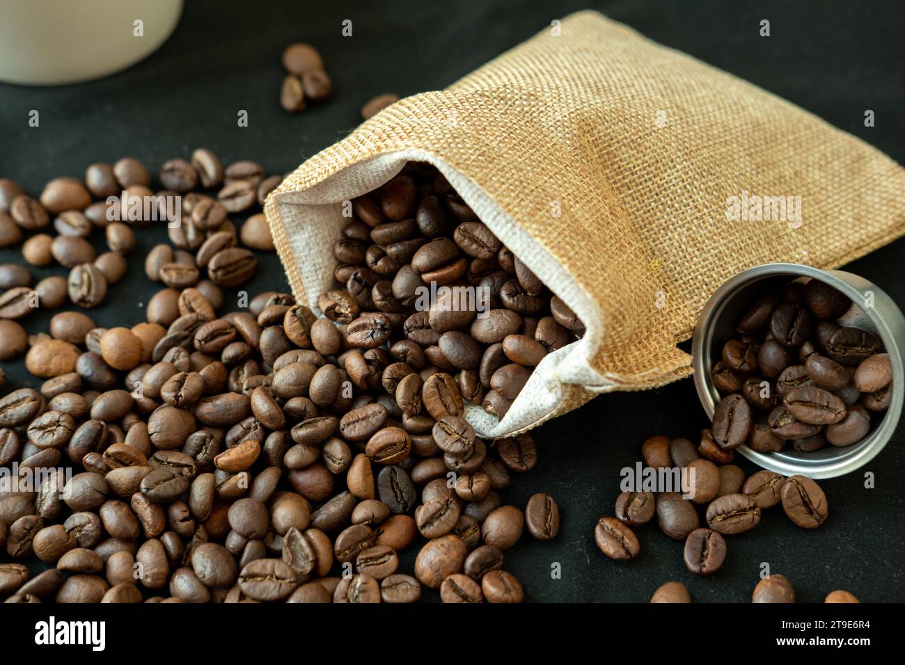 Kaffeebohnen in nachfüllbaren Kaffeekapseln, Kaffeebeuteln und auf schwarzem Hintergrund. Stockfoto