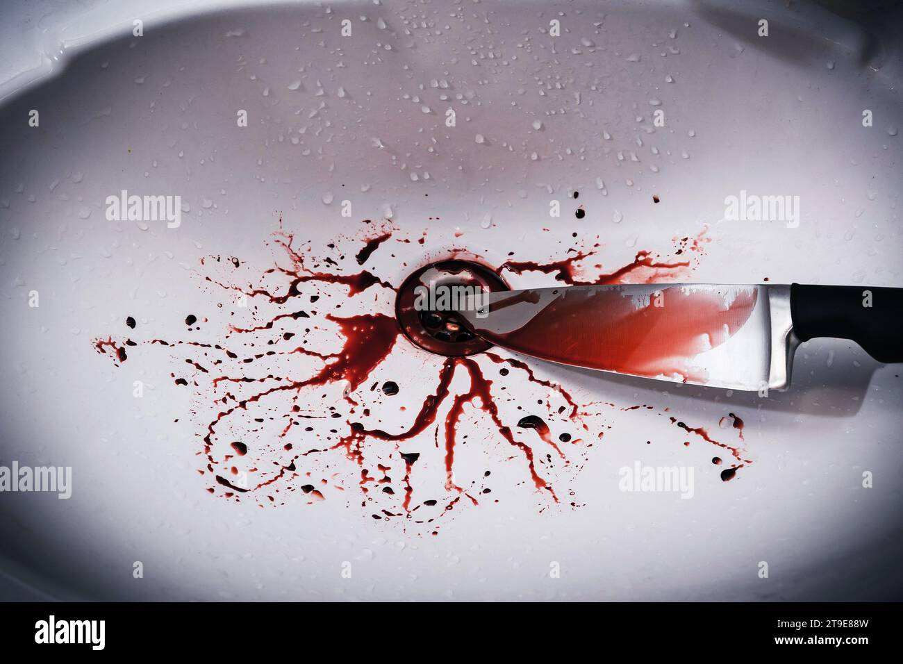 Nahaufnahme des schmutzigen Waschbeckens im Bad mit Blutspritzern und Messer Stockfoto