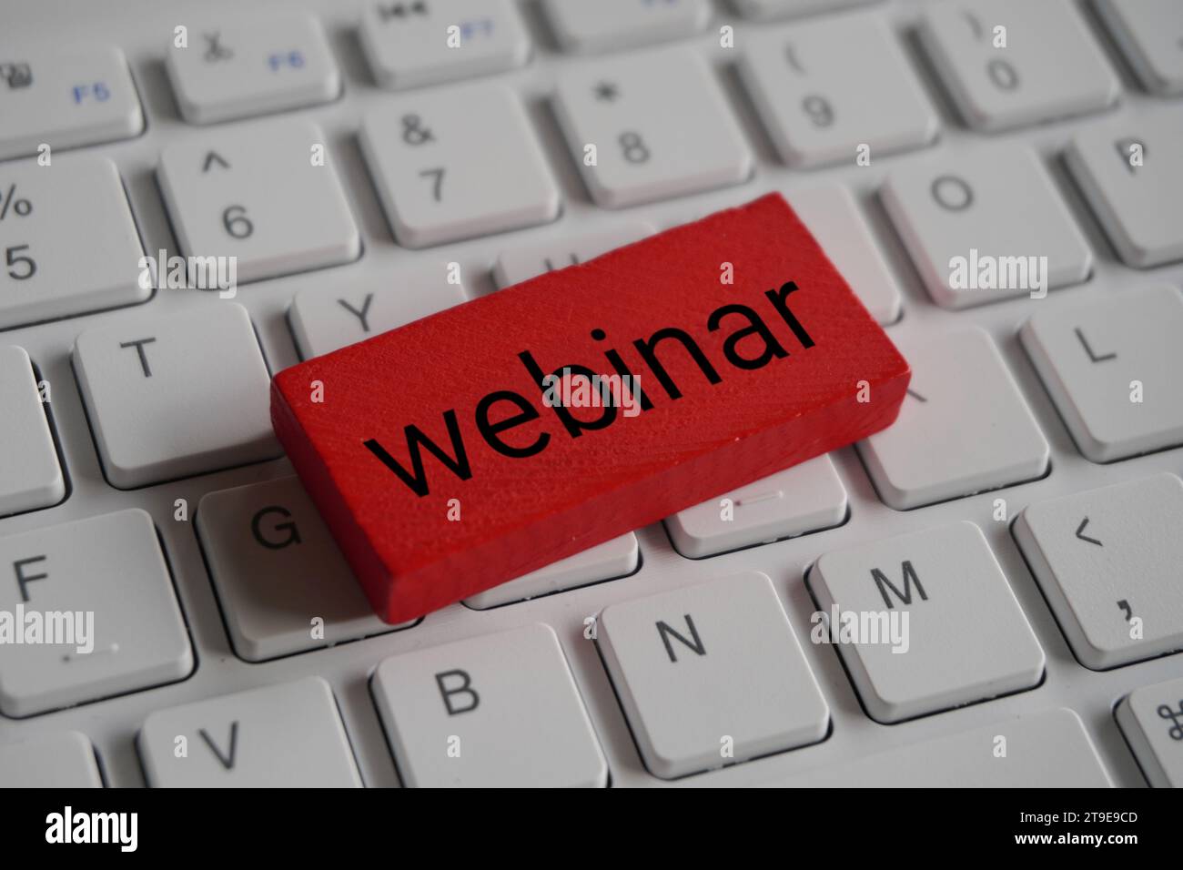 Nahaufnahme eines Holzblocks mit Text-WEBINAR auf der Computertastatur. Stockfoto