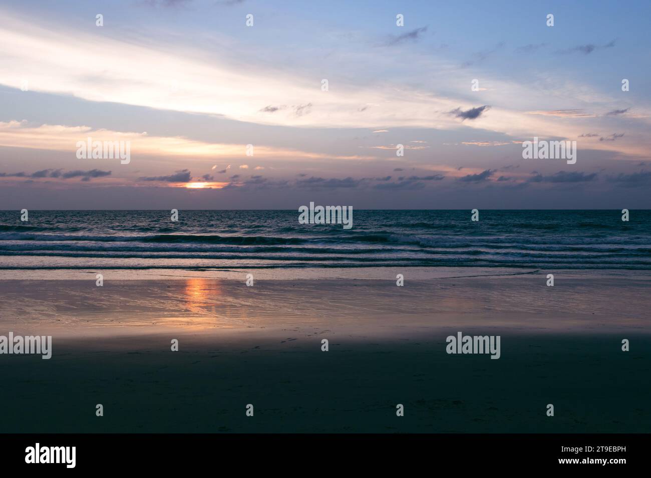 Wunderschöner Sonnenuntergang am Strand. Landschaftlich schöne Meereslandschaft mit Wolken, Wellen und Sonne. Stockfoto