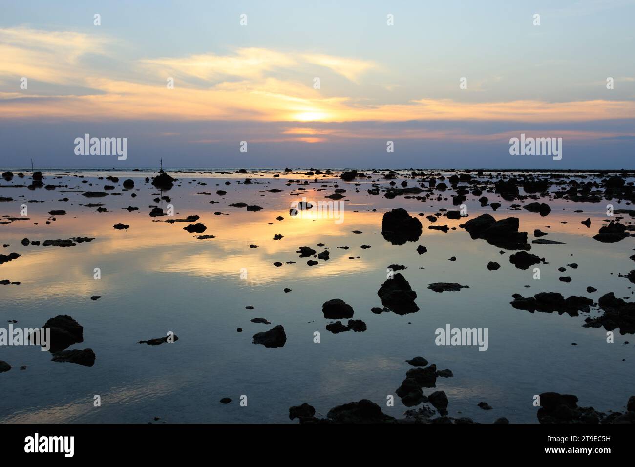 Wunderschöner Sonnenuntergang am Strand. Malerische Meereslandschaft mit Felsen während der Ebbe. Stockfoto