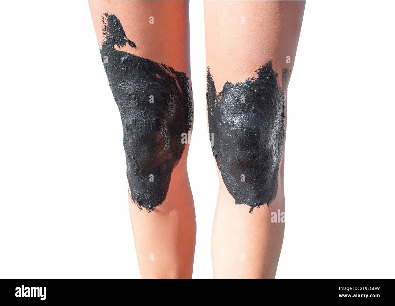 Frauen-Beine mit Knien, die mit therapeutischem Schlamm beschmiert sind, isoliert auf weißem Hintergrund mit Beschneidungspfad. Stockfoto