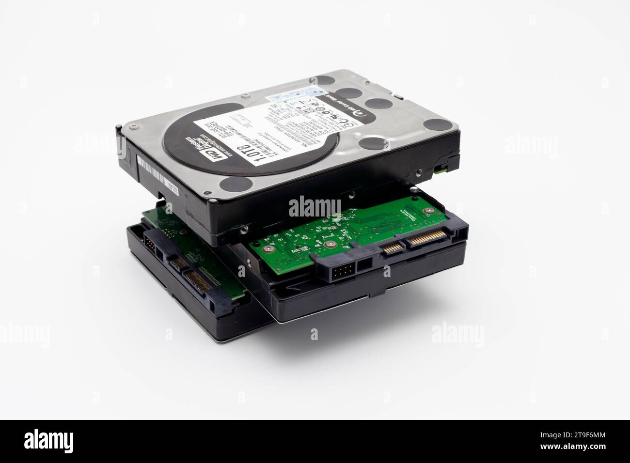 Drei gestapelte Festplatten, schwarz mit grünen Leiterplatten, zur Speicherung von Computerdaten. Stockfoto