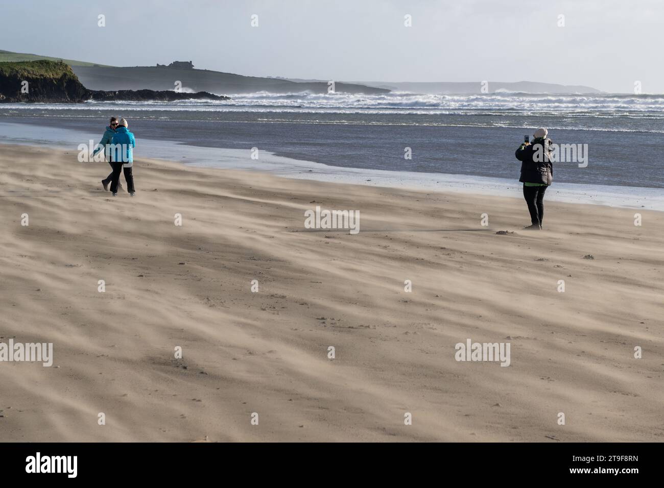 Irisches Wetter: Die Leute haben Spaß bei starkem Wind am Inchydoney Beach, West Cork, Irland. Stockfoto